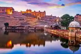 Amber Fort illuminated at twilight reflecting in Maota Lake near Jaipur