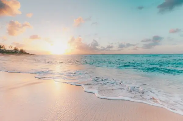 Serene Goa beach at sunset with gentle waves and pastel sky