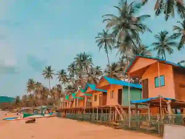 Colorful beach cottages with palm trees on Goa sandy beach