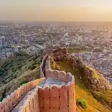 Sandstone fort ramparts overlooking the Pink City of Jaipur at sunset on the Golden Triangle tour
