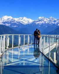 Couple on the Pelling glass Skywalk with snow-capped Kangchenjunga in view